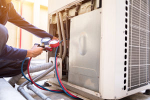 Technician is checking air conditioner ,measuring equipment